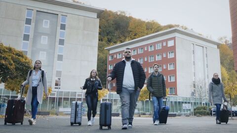 Ein neuer Lebensabschnitt 5 junge Menschen mit ihren Koffern laufen zum SZ-Campus