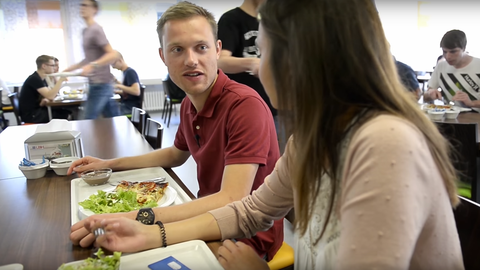 2 Anwärter sitzen am Tisch in der Mensa