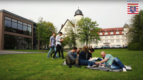 Anwärter sitzen auf einer Wiese vor dem Schloss in Rotenburg