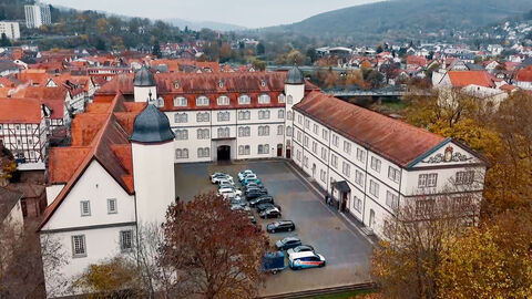 Drohnenaufnahme des Schlosses mit Fahrzeugen auf dem Schlossinnenhof