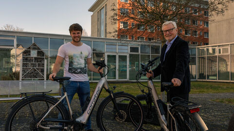 E-Bikes Freundeskreis Zwei Männer stehen hinter jeweils einem E-Bike.