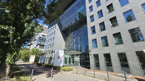 Bürogebäude mit einer großen Glasfront und eine Beschilderung mit dem Hessenlogo